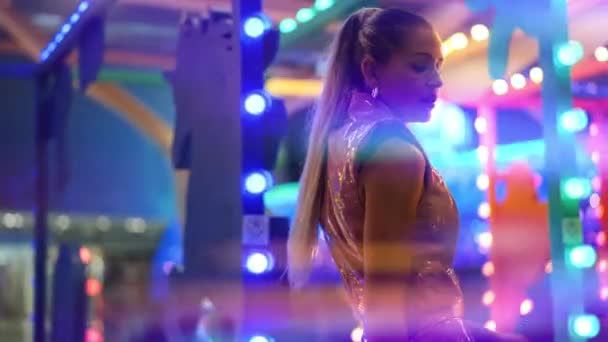 Vrouw in Pvc Clubkleding poseren onder Neon Fairground Lights — Stockvideo
