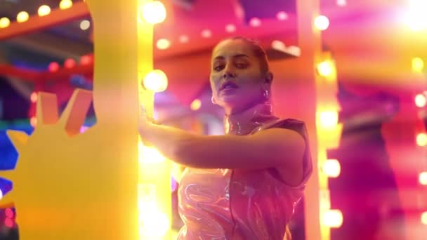 Vrouw in Pvc clubkleding poseren voor camera tussen neon lichten — Stockvideo