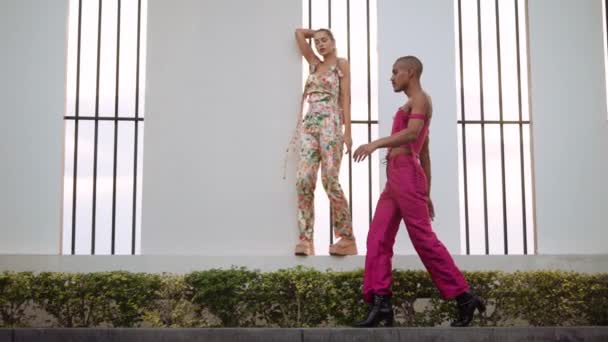 Uomo in clubwear rosa passeggiando passato giovane donna che balla — Video Stock