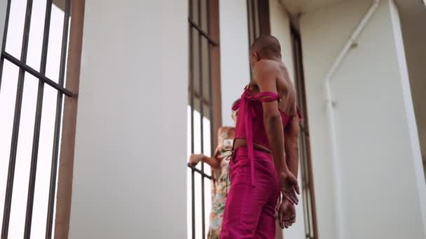 Tänzer posieren und bewegen sich in Klubkleidung durch vergitterte Fenster — Stockvideo
