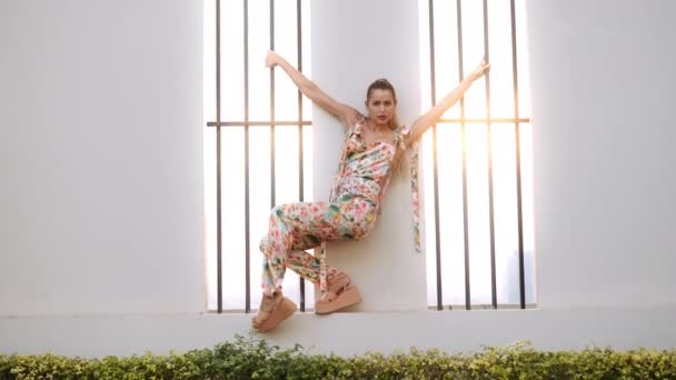 Mujer bailando en ropa de moda sosteniendo barras de ventana — Vídeos de Stock