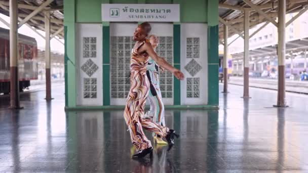Motemodeller danser og ler på togstasjonen – stockvideo
