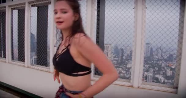 Brunetka dziewczyna taniec do kamery w żółty na dachu — Wideo stockowe