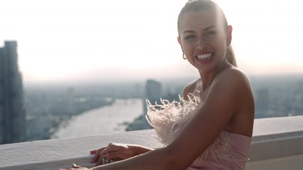 Schönes Model lächelt an der Brüstung über der Stadt — Stockvideo