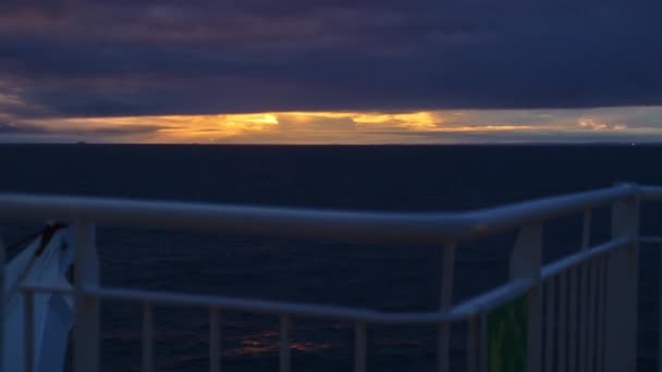 Ponte del traghetto che si muove attraverso l'oceano mentre il sole tramonta — Video Stock