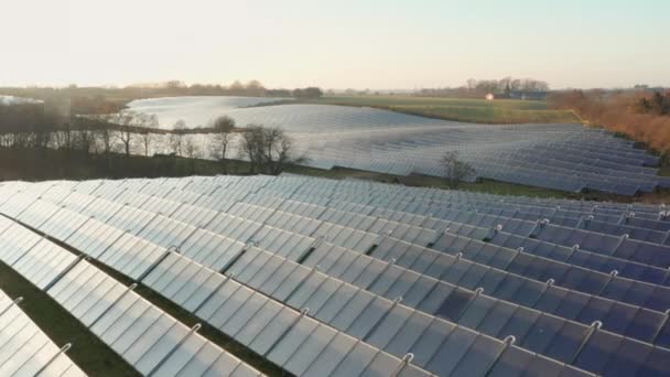 Drone sopra pannelli solari in campagna sotto il sole tramontante — Video Stock