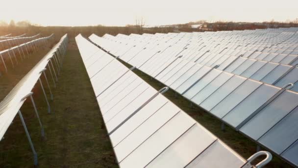 Drönare över solbelysta rader av solpaneler på landet — Stockvideo