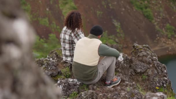 Pár sedí spolu na skalách v Thingvellir — Stock video