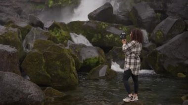 Oxarfoss Şelalesi 'ni çekmek için Süper 8 Kamera kullanan Kadın