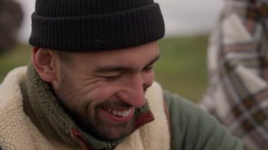 Yünlü şapkalı gülen adam gülüyor ve uzaklara bakıyor.