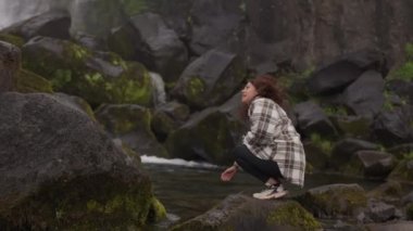 Oxararfoss Şelalesi 'nin yanındaki Kaya' da Çömelen Kadın