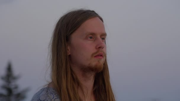 Fiatal férfi hosszú hajjal meditál a háztetőn — Stock videók