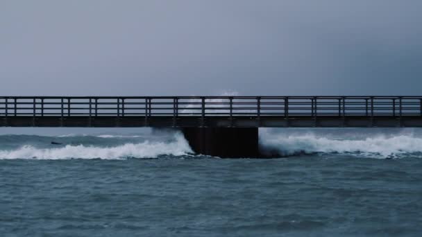 Surowe morze spowodowane przez burzę fale pod molo balustrady — Wideo stockowe