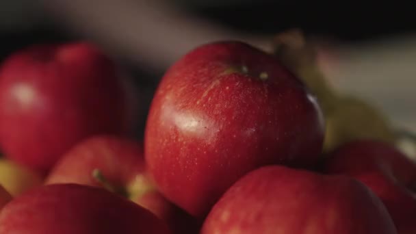 Vrouw reiken naar rijpe, rode appel uit fruitschaal — Stockvideo