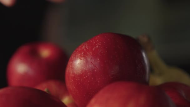 Mujer alcanzando maduro, manzana roja de tazón de fruta en la cocina — Vídeos de Stock