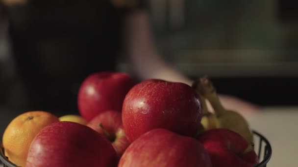 Mujer alcanzando maduro, manzana roja de tazón de fruta — Vídeos de Stock