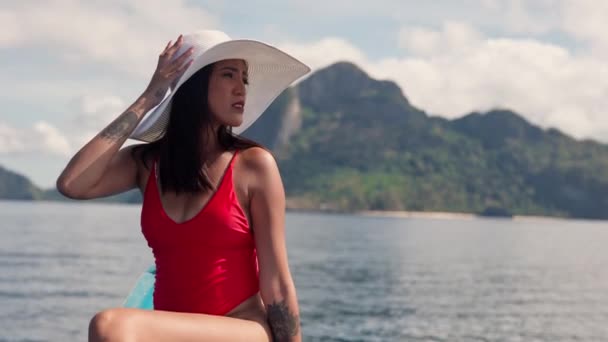 Kobieta w kostiumie kąpielowym i kapeluszu na pokładzie łodzi — Wideo stockowe