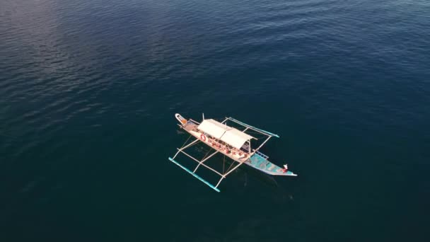 Drone over zonovergoten zee met vrouw op Outrigger boot, — Stockvideo