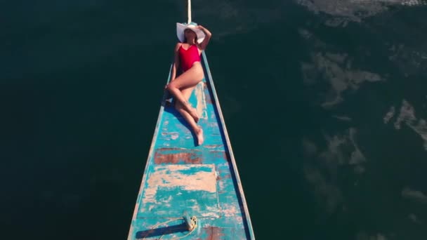 Drohne über dem Meer mit Frau beim Sonnenbaden auf Outrigger-Boot — Stockvideo