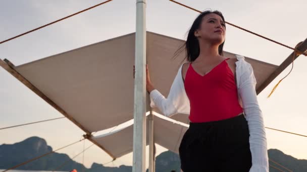 Młoda kobieta trzyma maszt łodzi i patrząc daleko — Wideo stockowe