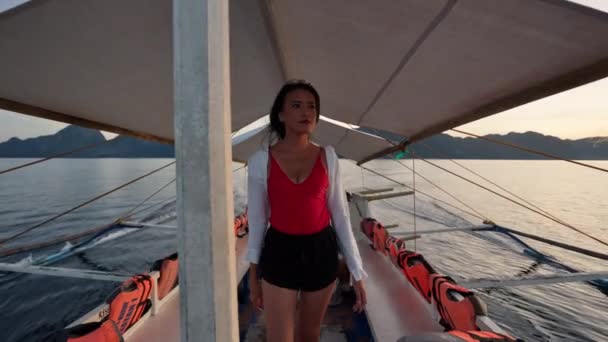 Mulher andando ao longo do convés do barco para olhar para fora sobre o mar — Vídeo de Stock