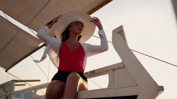 Женщина отдыхает на яхте Outrigger Boat In Sun Hat — стоковое видео