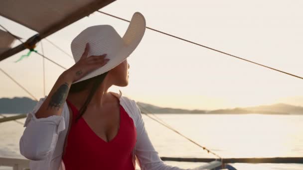 Žena relaxační na obrysu lodi v klobouku slunce — Stock video