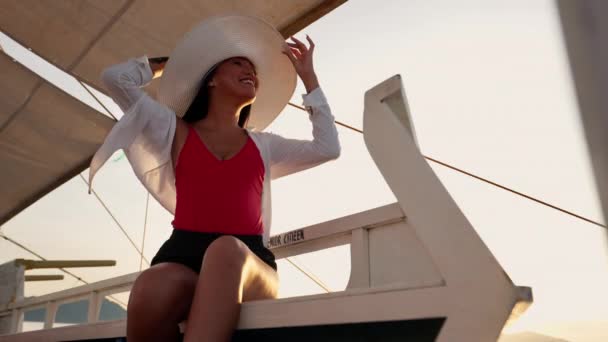 Mujer sonriendo en sombrero de sol en barco Outrigger — Vídeo de stock