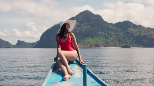 Vrouw in badpak en zonnehoed zonnebaden op het dek van de boot — Stockvideo