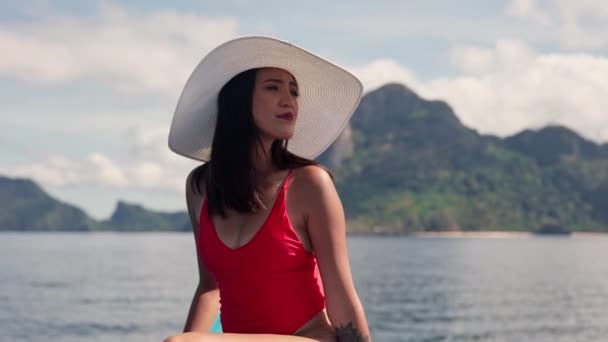 Kobieta w kostiumie kąpielowym i kapeluszu na pokładzie łodzi — Wideo stockowe