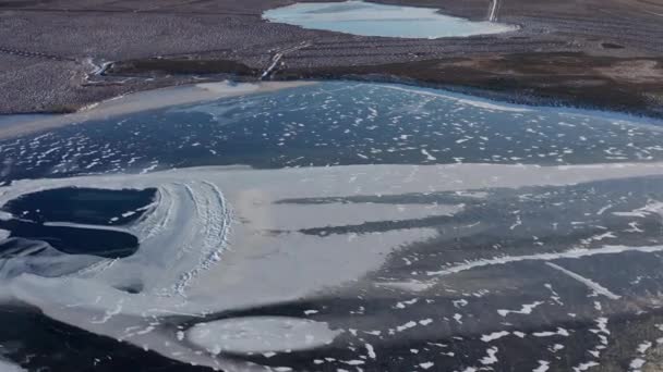 Drohnenflug über gefrorenem See und kalter Landschaft — Stockvideo