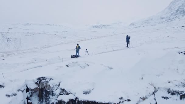 Drönare av fotografer med stativ i snö — Stockvideo