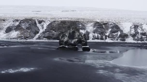 Dron oblouk kolem Hvitserkur na černé písečné pláži — Stock video