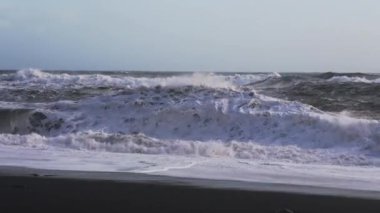 Güneş Işığı Fırtınalı Deniz Kayalara ve Kara Kum Sahiline Çarpıyor