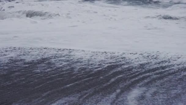 Ondas de tempestade branca batendo na praia de areia preta — Vídeo de Stock