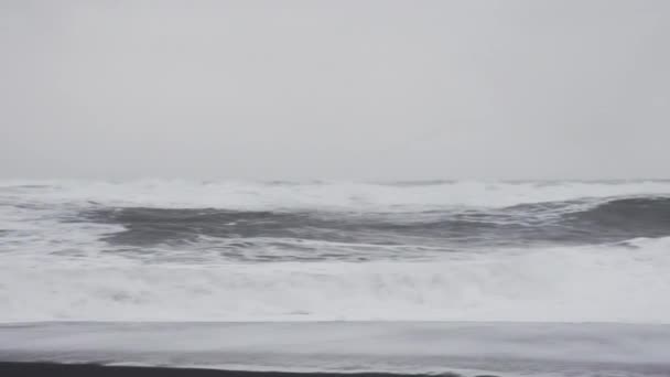 Ondas brancas tempestuosas chegando à praia de areia preta — Vídeo de Stock