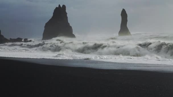 Misty Sea Stacks y estrellarse mar en la playa de arena negra — Vídeo de stock
