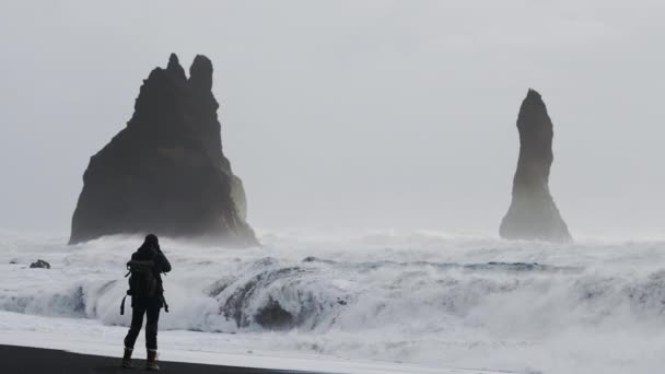 Fotograf biegnie, aby uniknąć przypływu z aparatem fotograficznym na plaży Black Sand — Wideo stockowe