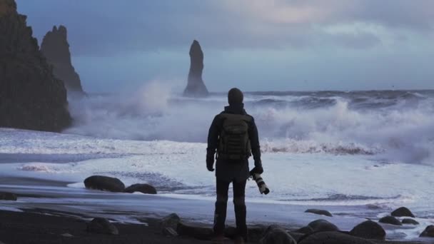 Fényképész a Black Sand Beach nézi Viharos tenger — Stock videók