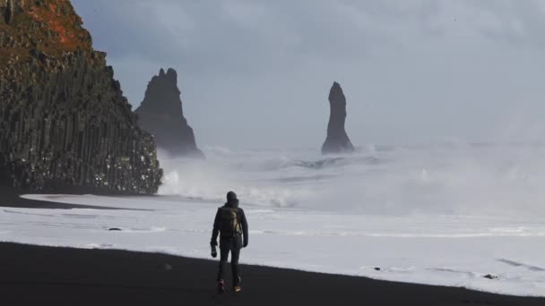 Fotograf na plaży Black Sand Oglądanie ostrego morza — Wideo stockowe