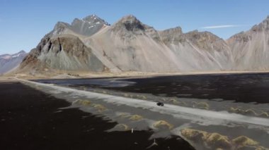 Dar yol boyunca Vestrahorn 'a doğru alçak dalgalarla giden aracın drone' u