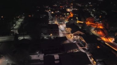 Drone Arcing Over Buildings At Night In Town Of Kaprun