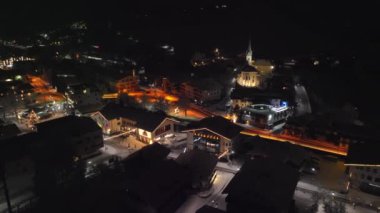 Drone Arcing Over Buildings At Night In Town Of Kaprun