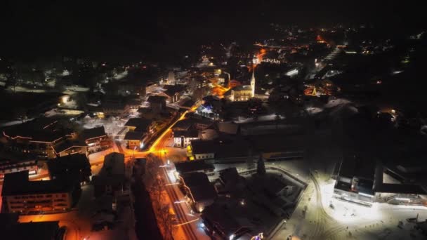 Drone vlucht boog boven verlichte Kaprun 's nachts — Stockvideo