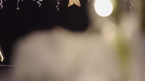 Christmas Star Hanging From Line Covered With Fairy Lights At Night — Stock Video