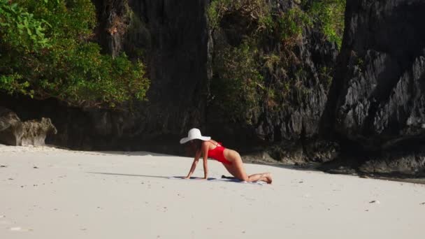 Woman In Red Swimsuit Kneeling And Lying To Sunbathe On Beach — Stockvideo