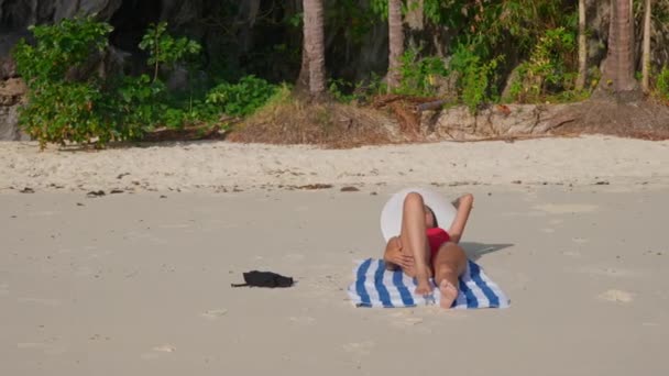 Γυναίκα με μαγιό και ηλιοθεραπεία στην παραλία — Αρχείο Βίντεο