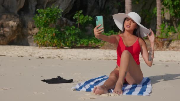 Γυναίκα κάθεται στην παραλία Posing με Smartphone — Αρχείο Βίντεο