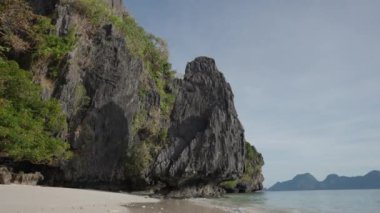 Entalula Sahili 'nin dalgalı ve kayalıklı kumsalı.