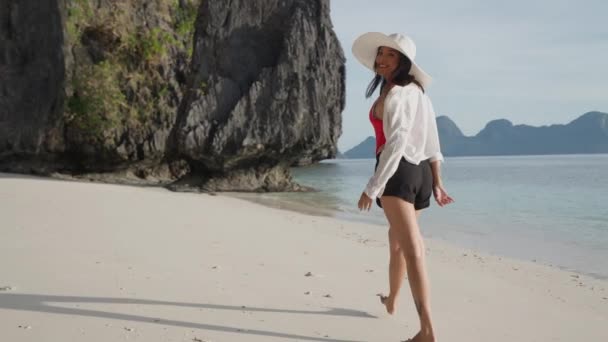 Молодая женщина улыбается и ходит по пляжу Энталула — стоковое видео